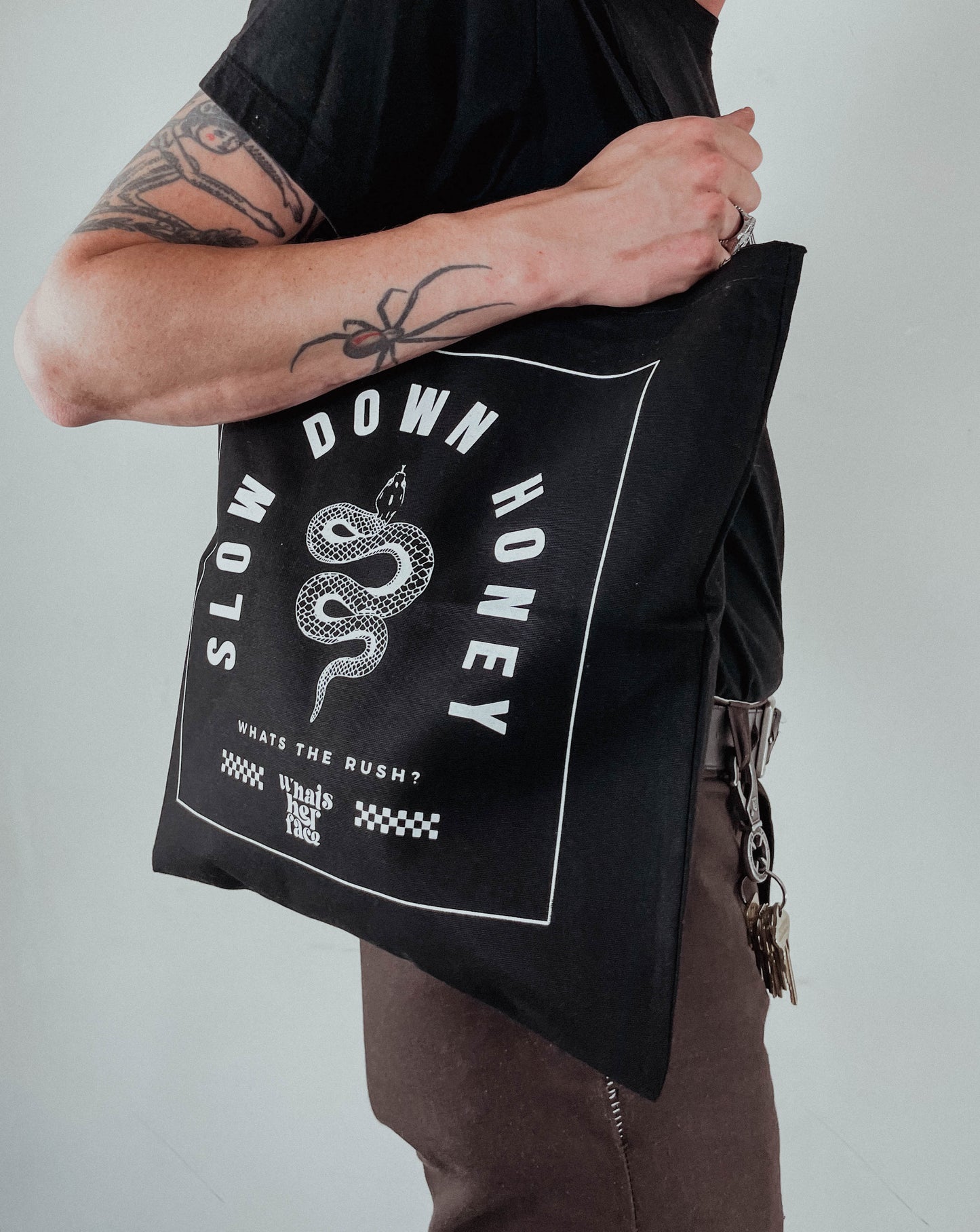 Black tote bag with snake and slow down honey graphic